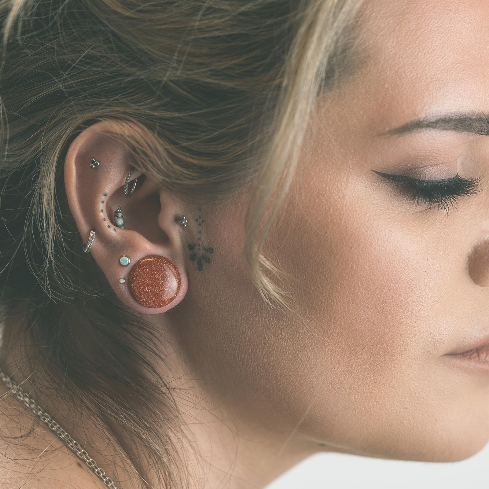 Model With Stretched Ears Wearing Stone Ear Gauges