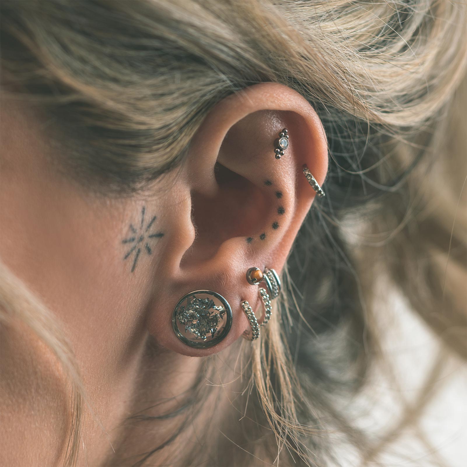 Model With Stretched Ears And Different Types Of Ear Piercings