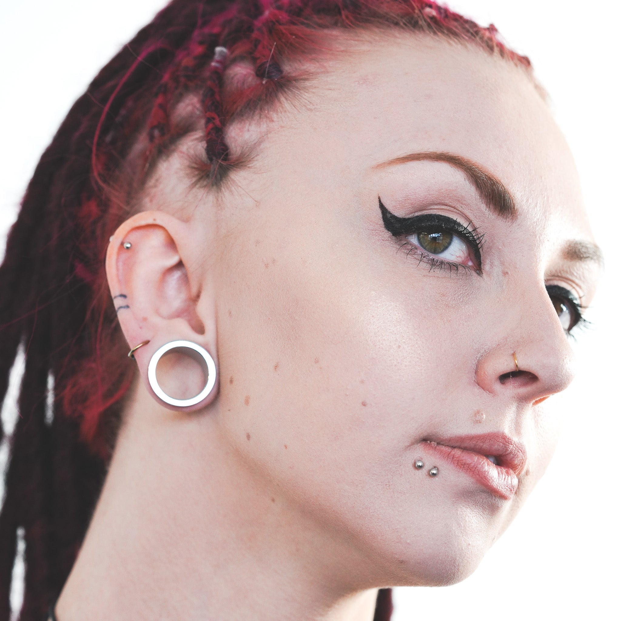 Model wearing surgical steel tunnels for stretched ears