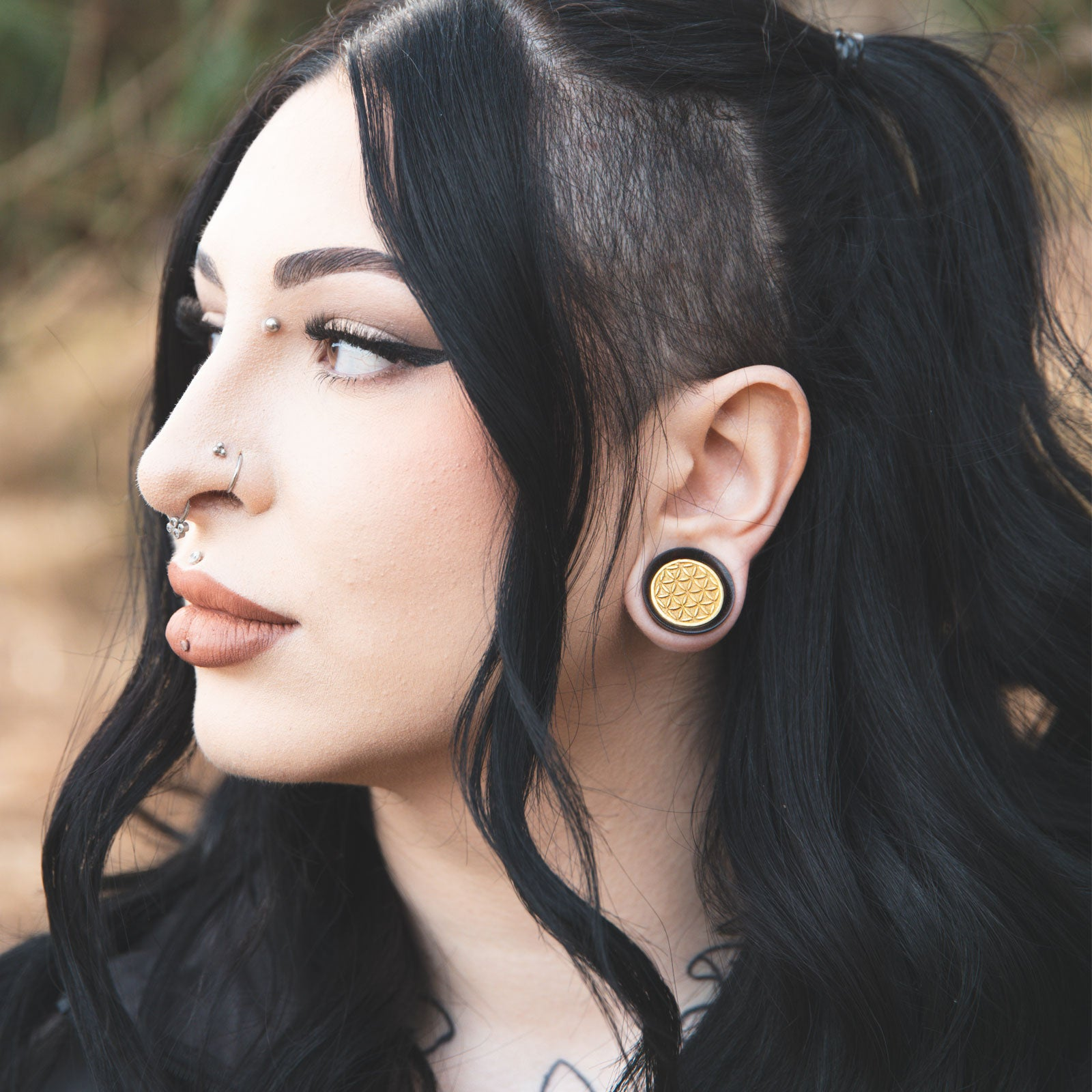 model wearing brass and wood plug