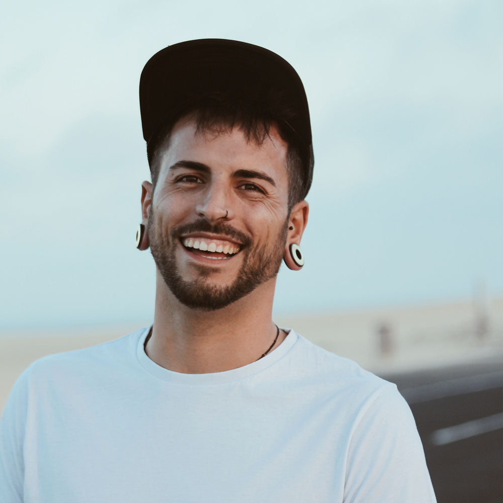 smiling model wearing large flesh tunnels