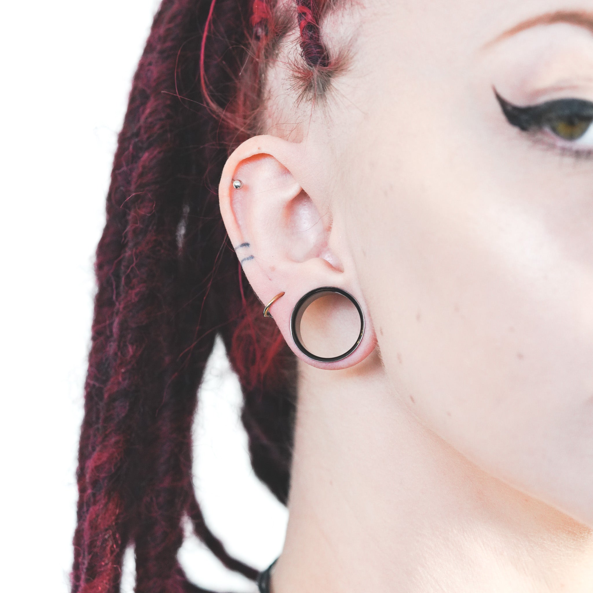 model close up wearing 20mm black pvd ear gauges from stretch it body jewellery