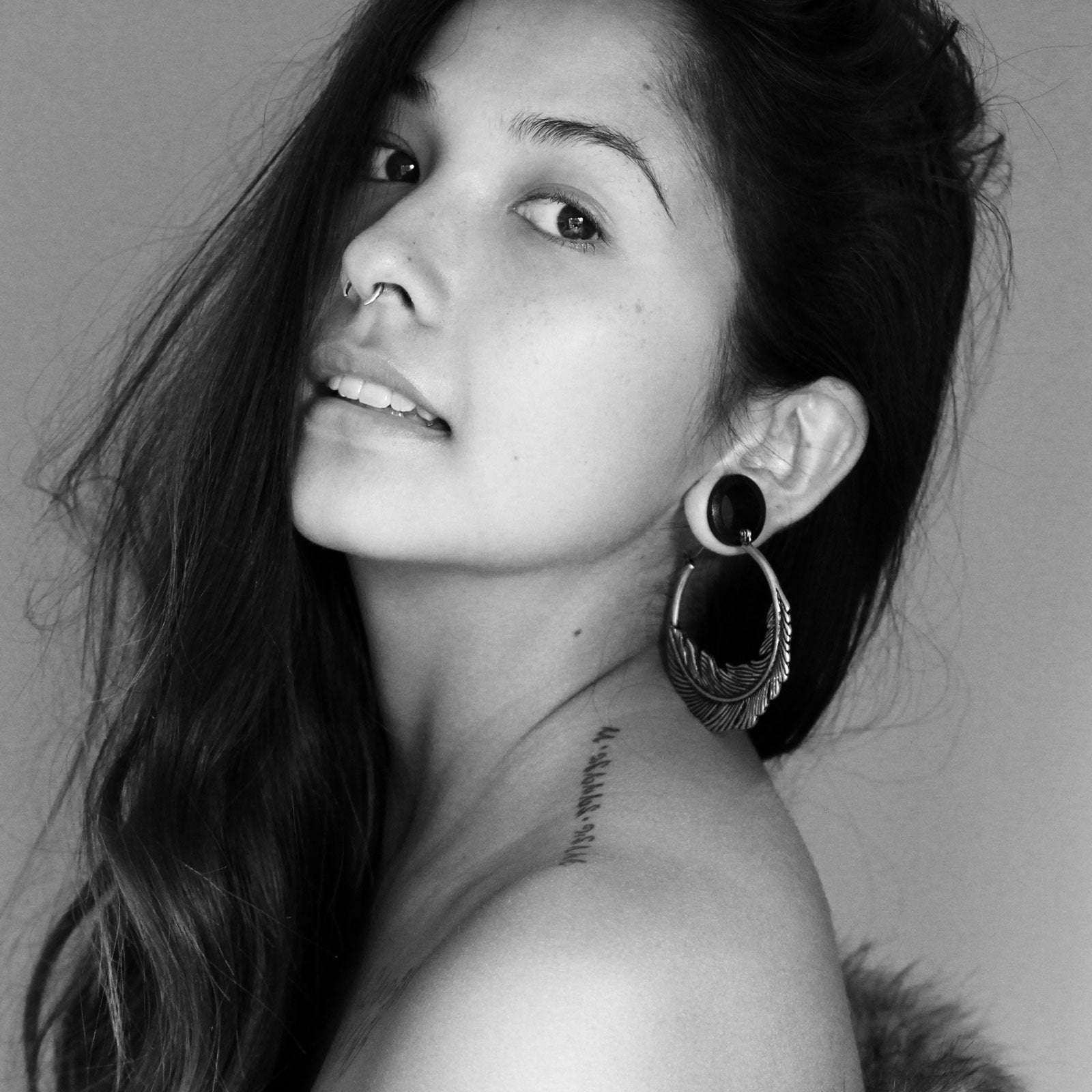 Naomi King Wearing Feather Plug Hoops